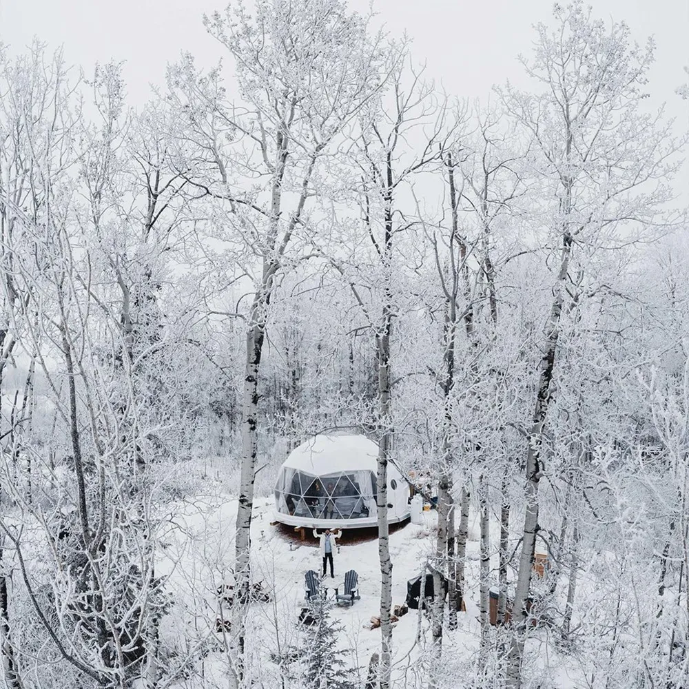 Exterior shot of ignis dome during the winter with the entire campsite and forest covered in snow