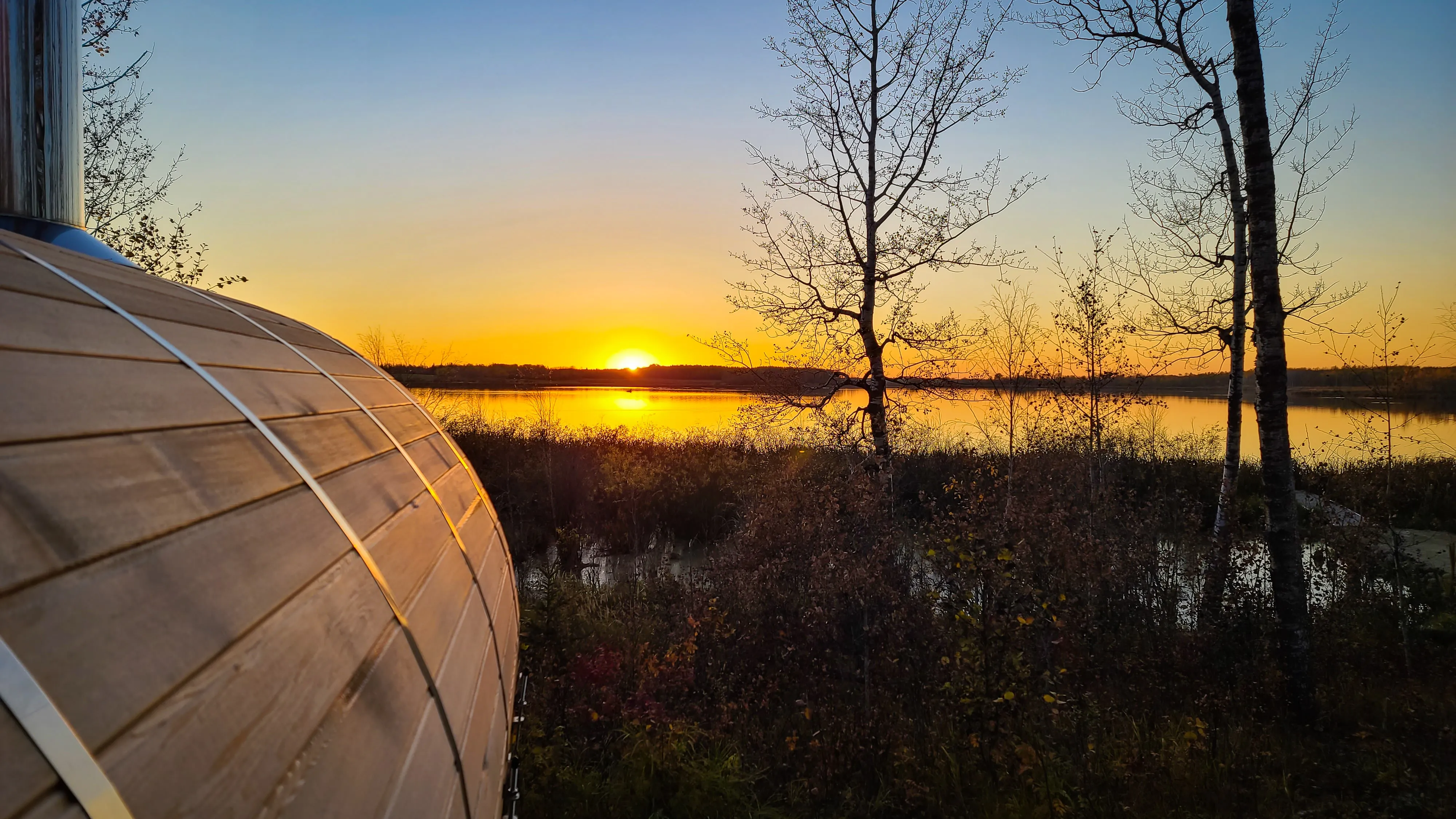 nature sunset view overlooking lake with outdoor sauna