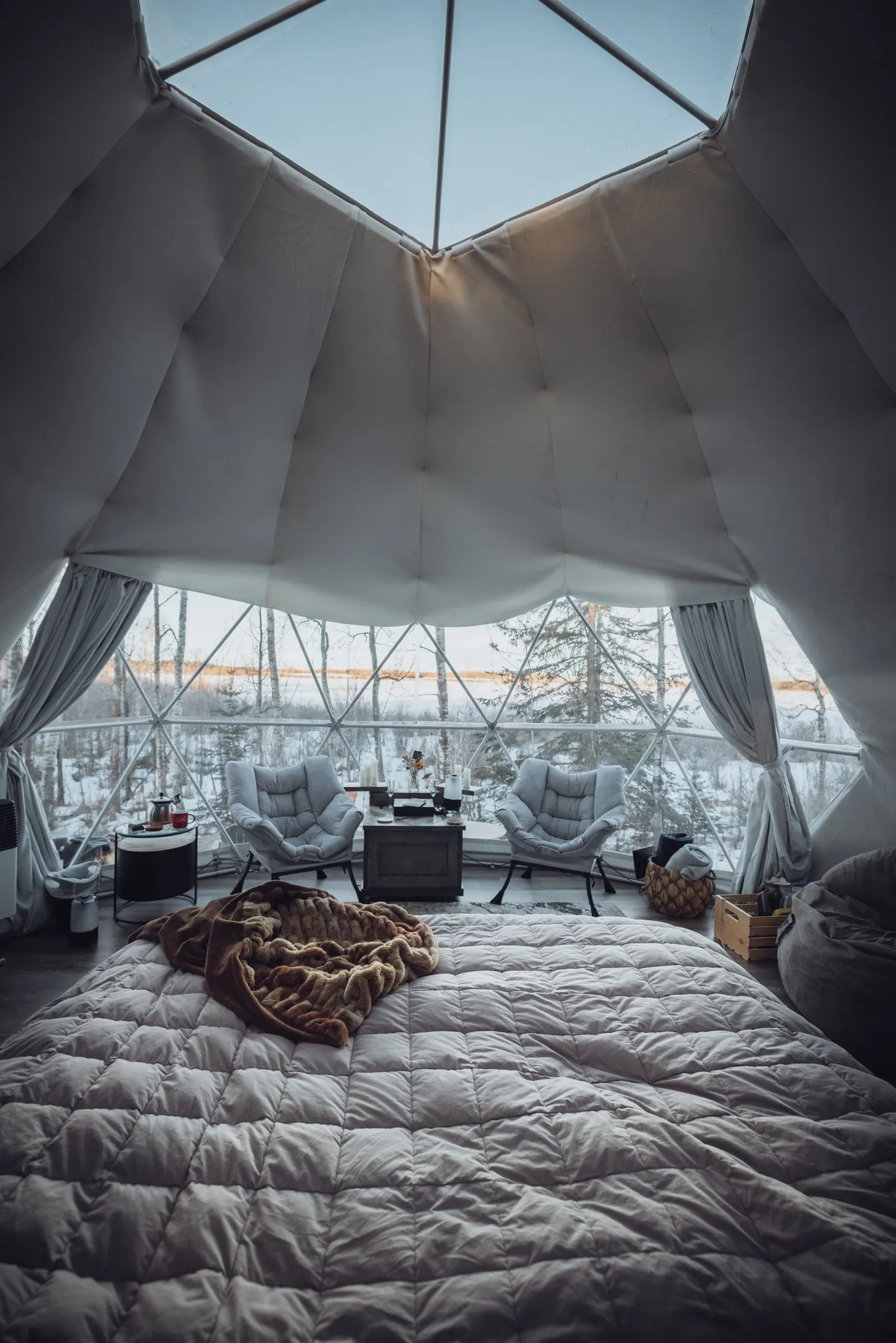 wide angle interior shot of ignis dome with queen size bed and two lounge chairs