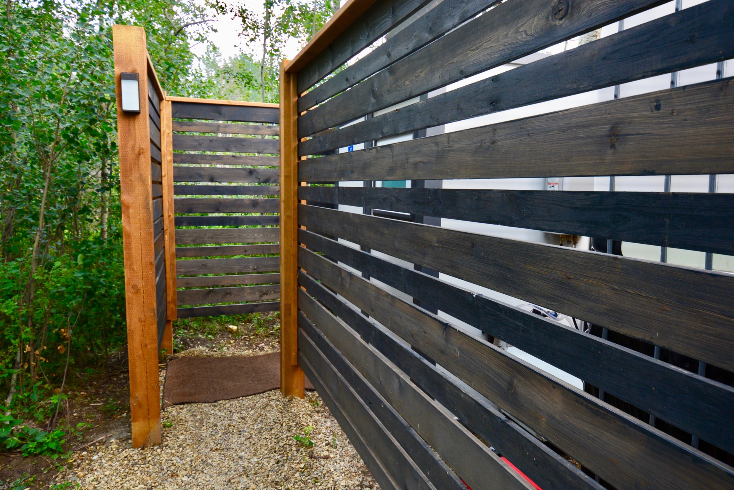 Wood fenced entrance to bathroom located outside of ignis dome