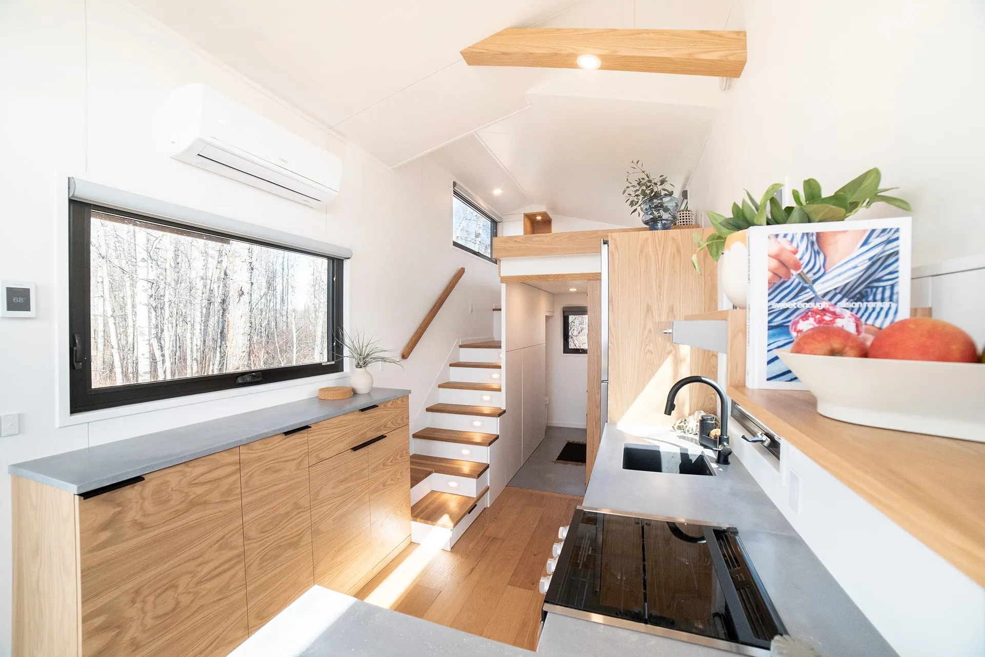 aqua tiny homes interior angled view of main floor with modern kitchen in a small space